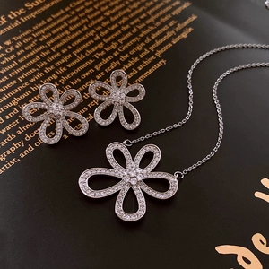 Vue détaillée du collier et des boucles d'oreilles fleurs en argent avec oxydes de zirconium