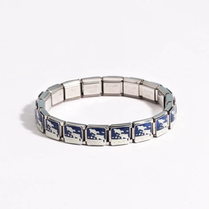 Macro shot of silver stainless steel Italian charm bracelet with blue and white enamel