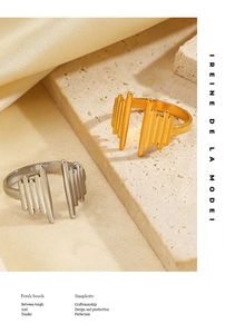 Detail of minimalist 18K gold and silver plated wave rings on stone and silk background