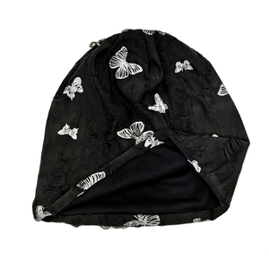 Distressed black knit beanie with silver butterfly prints in casual Y2K aesthetic