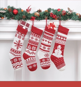 Dettaglio di quattro calze di Natale in maglia con motivi nordici su una corona festiva