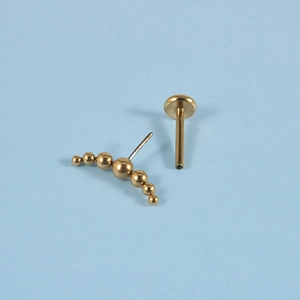 Macro shot of gold stainless steel curved labret stud with a seven-ball arc decoration