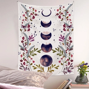 Detail of bohemian moon phase tapestry with floral patterns hanging over a cozy bed