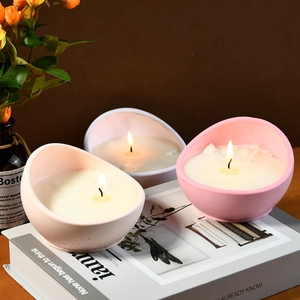 Drie halfronde pastelroze kaarsen op boeken voor een minimalistisch interieurdecor