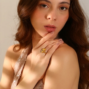 Asymmetric flower pavé ring in 18K gold plated stainless steel worn by a model