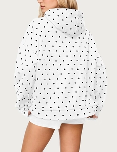 Rear view of a white oversized hoodie featuring black polka dots and a cozy hood
