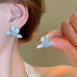Macro detail of a silver flower earring with crystal texture and rhinestone centerpiece