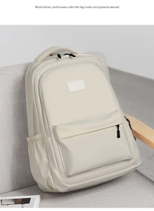Detail view of a cream white nylon backpack on a chair showing durable fabric texture