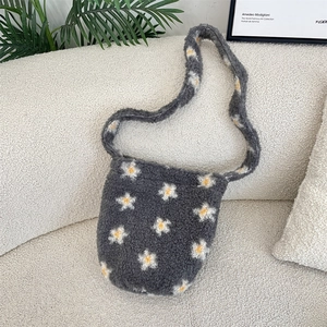 Detailed view of grey faux shearling fabric with white daisy patterns on a plush tote bag