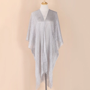 Close-up of the silver glitter fabric texture and fringe detail on the women's shawl