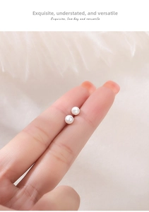 Close-up of minimalist S999 sterling silver stud earrings with elegant white round pearls