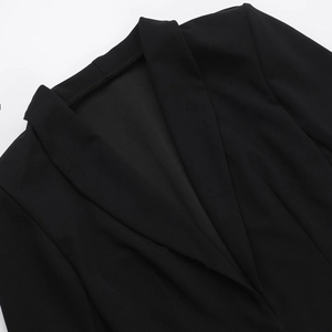 Détail du décolleté plongeant en V et du revers d'une robe blazer noire de style chic