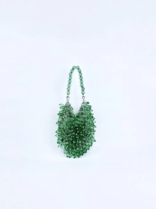 Close-up of handmade emerald green beaded bag with faceted acrylic beads and metallic hook