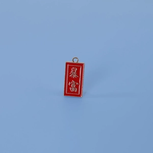 Détail macro du pendentif en émail rouge avec calligraphie chinoise de richesse sur bleu