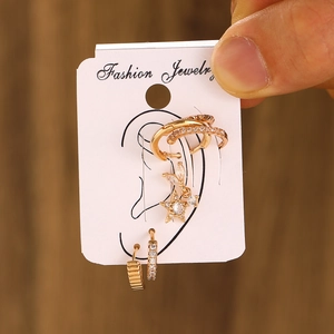 Close-up of five-piece gold earring set with zircons on a jewelry display card