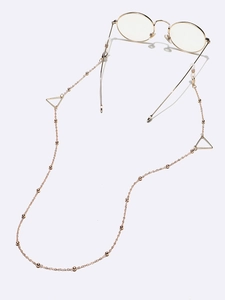 Detail of gold glasses chain with metal beads and hollow triangle geometric accents