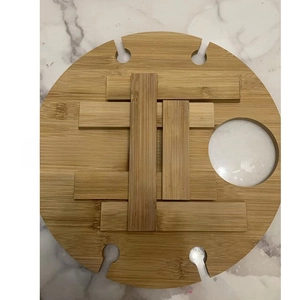 Top-down view of round bamboo outdoor wine table with glass holders on marble background