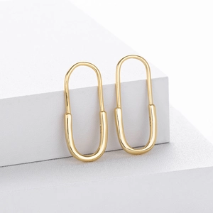 Detail view of gold-plated S925 silver safety pin earrings with a polished mirror finish