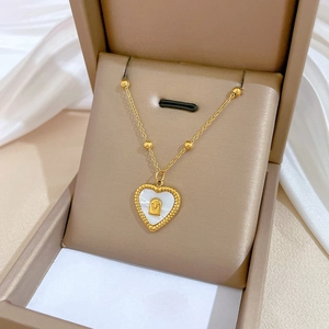 Golden titanium steel necklace with heart shell pendant and V design in a jewelry box