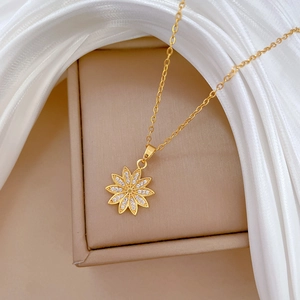 Detailed view of a gold flower pendant with sparkling zircon crystals on an O-chain