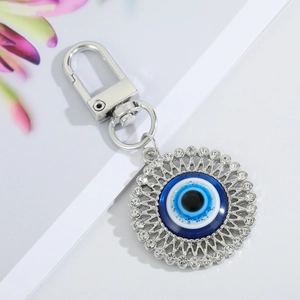 Detailed view of evil eye keychain with blue crystals and silver filigree border