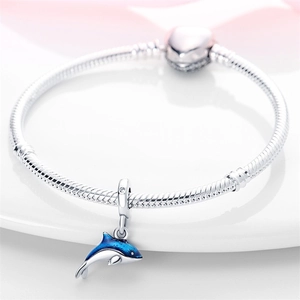 Detail of silver dolphin charm with blue enamel on a classic snake chain bracelet