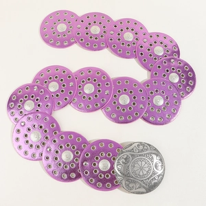 Detail of purple faux leather belt with silver carved buckle and round disk links