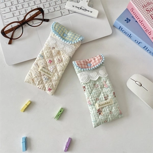 Close-up of quilted floral glasses pouches with lace trim and heart button details
