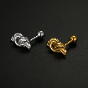Detailed macro view of interlocking silver and gold knot stud earrings in 16G stainless steel
