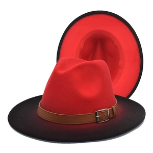 Detail of red and black gradient wool fedora hat with brown leather strap and metal buckle
