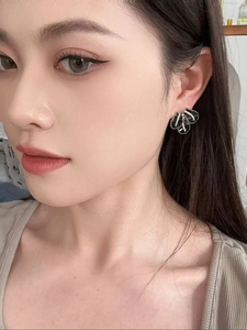 Detail shot of elegant black layered fan earrings with sparkling zircon accents on a model