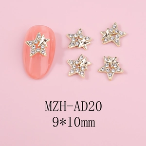 Detailed macro view of 9x10mm gold star nail charms with white rhinestones on pink nails