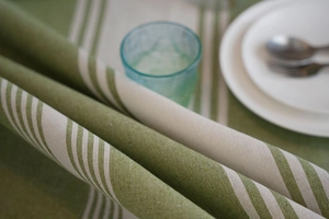 Close-up of green and beige striped linen texture tablecloth with soft fabric folds