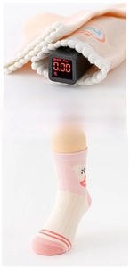 Détail de chaussettes bébé roses montrant un test de fluorescence à 0,00 et dentelle