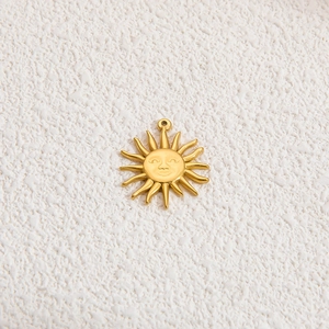 Detailed view of sun-shaped pendant in 18k gold-plated stainless steel with facial features