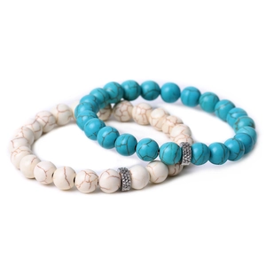 Close-up of beaded couples bracelets with tiger eye and turquoise stones on white background