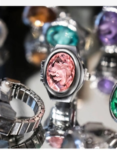 Close-up of vintage silver finger watch featuring an oval dial with pink floral relief