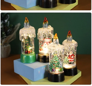 Close-up of four LED Christmas snow globe candles with glitter and Santa Claus scenes