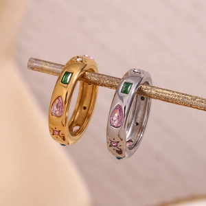 Detailed view of gold and silver wide bands with pink pear and green rectangle zircons