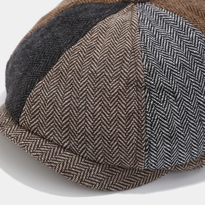 Close-up of herringbone tweed fabric showing multicolor stitching on the newsboy hat