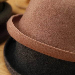 Detail of wool felt cloche hat showing fine stitching and curled brim craftsmanship