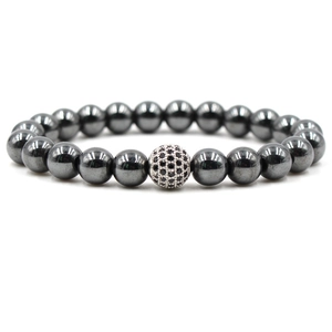 Close-up of natural hematite bead bracelet with a crystal-studded charm on white background