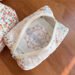 Internal view of floral quilted toiletry bag showing large storage capacity and soft lining