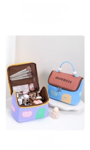 Detail of open house-shaped makeup bag with pearl handle and brush slots in purple