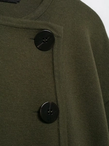 Detailaufnahme der olivgrünen Strickjacke mit großen schwarzen zylindrischen Knöpfen