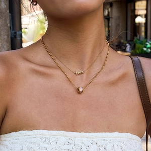 Zweilagige Goldkette mit Love-Anhänger und zylindrischem Anhänger mit rosa Edelstein