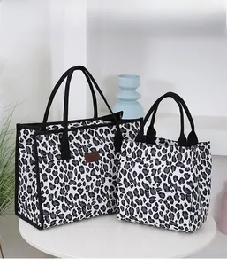 Detail of leopard print tote bags in two sizes featuring black canvas handles and logo