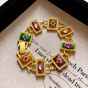 Vue macro des maillons de bracelet en émail avec pierres colorées et finition dorée mate