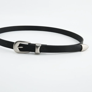Detail of minimalist black leather belt featuring a silver horseshoe buckle and metal tip