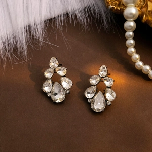 Detailed macro view of silver drop earrings with pear-shaped crystals on vintage background